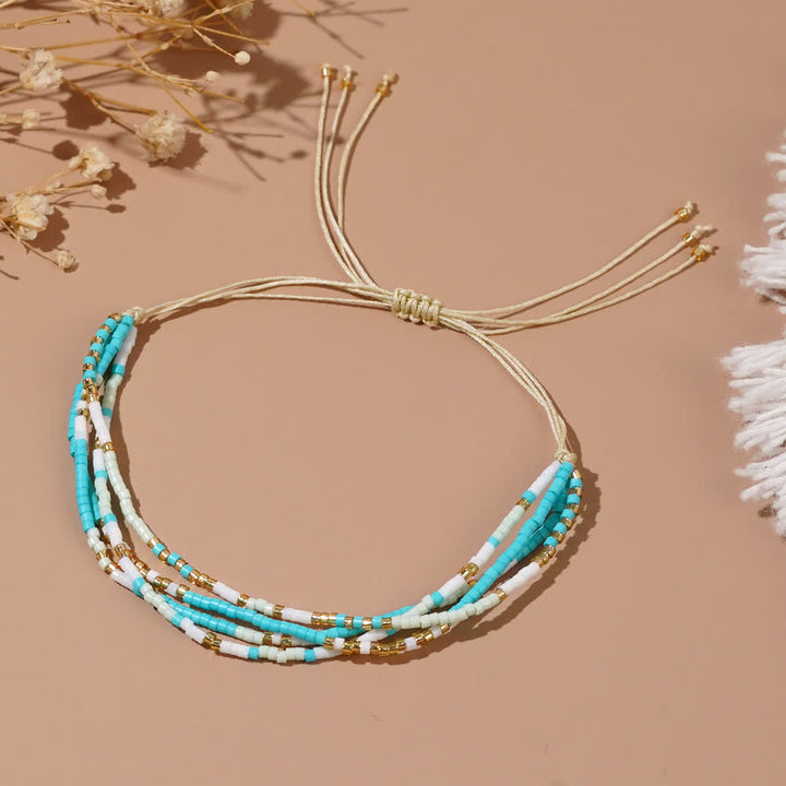 Olivenorma Braccialetto da spiaggia intrecciato con perline di riso bianco e blu 