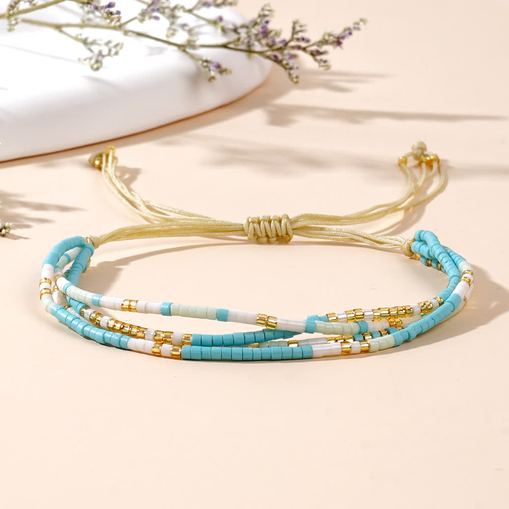 Olivenorma Braccialetto da spiaggia intrecciato con perline di riso bianco e blu 