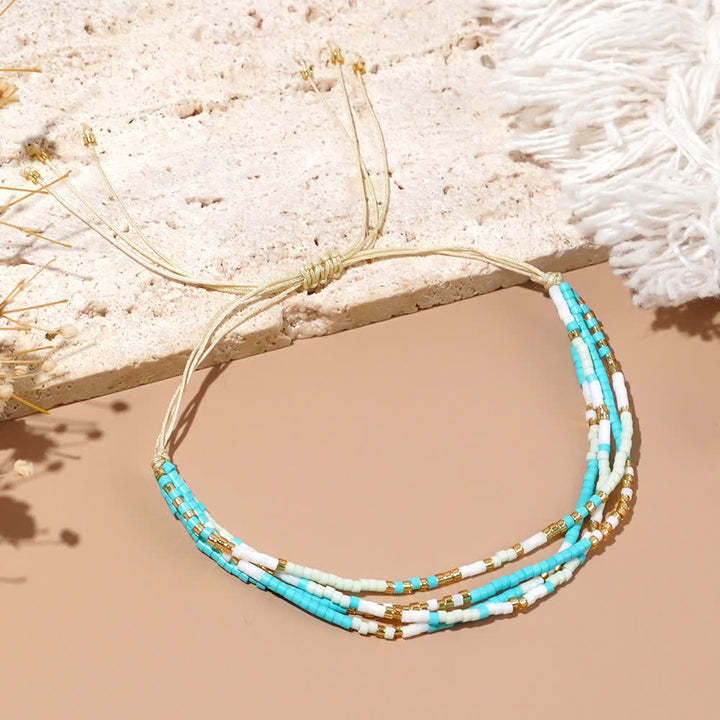 Olivenorma Braccialetto da spiaggia intrecciato con perline di riso bianco e blu 