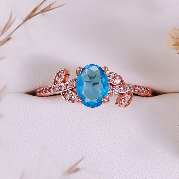 Anello Olivenorma con topazio blu ovale avvolto a foglia