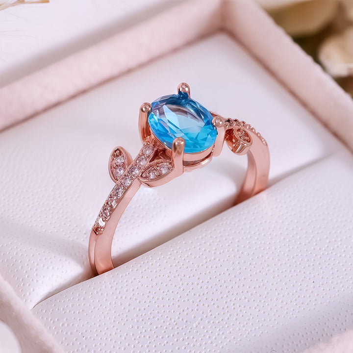 Anello Olivenorma con topazio blu ovale avvolto a foglia