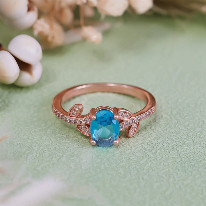 Anello Olivenorma con topazio blu ovale avvolto a foglia