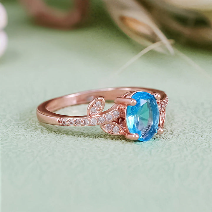 Anello Olivenorma con topazio blu ovale avvolto a foglia
