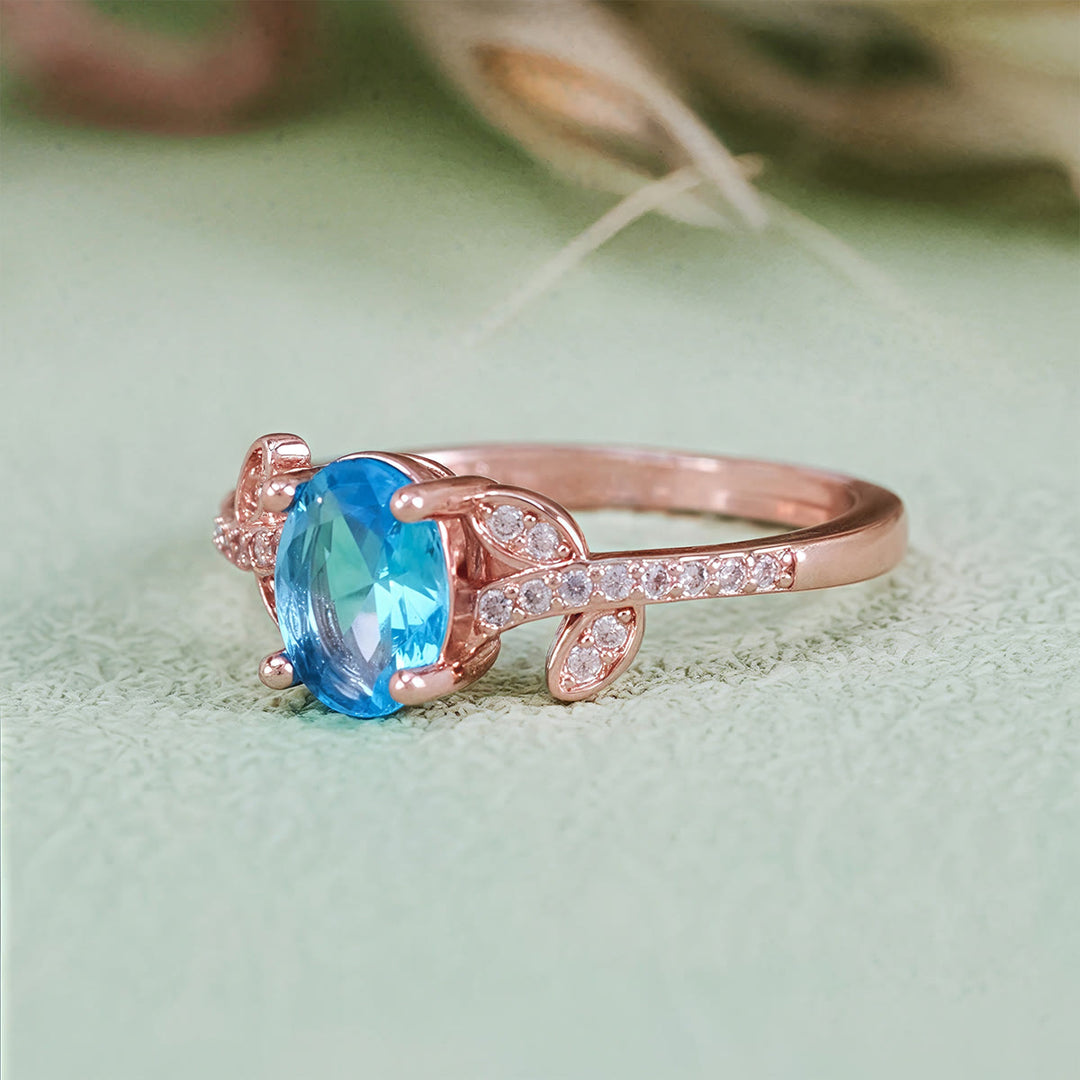 Anello Olivenorma con topazio blu ovale avvolto a foglia