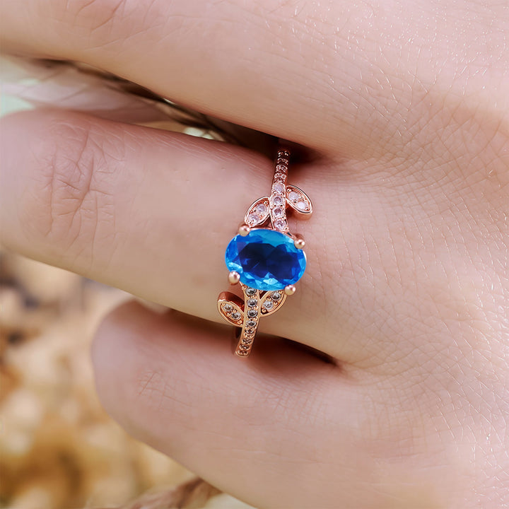 Anello Olivenorma con topazio blu ovale avvolto a foglia