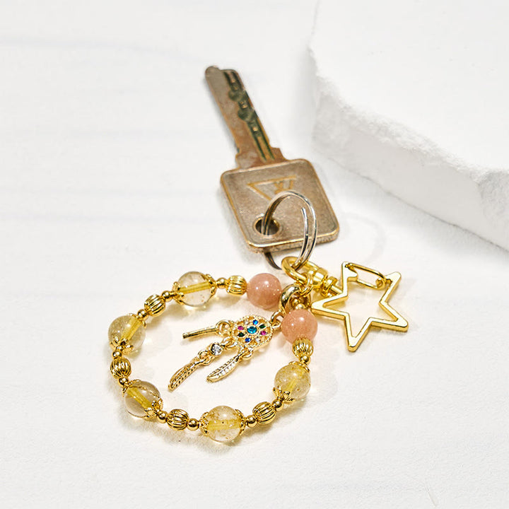 Portachiavi con cinturino per telefono in cristallo di quarzo rutilato dorato e pietra del sole Olivenorma - image 1