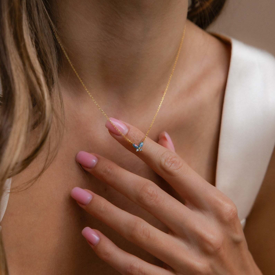 Collana Olivenorma con ciondolo a farfalla in opale blu rosa e acciaio al titanio