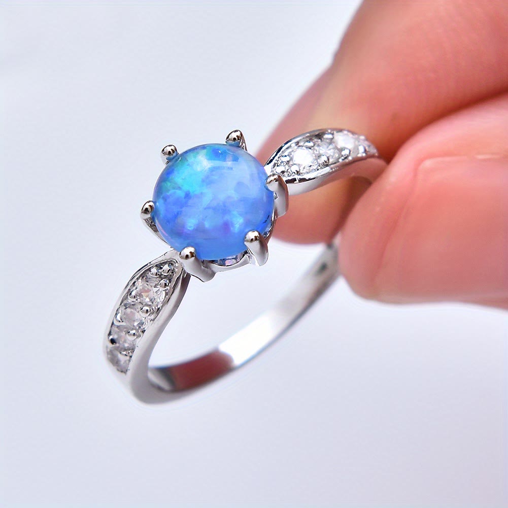 Anello Olivenorma con fascia a sei griffe e bordo in opale rotondo