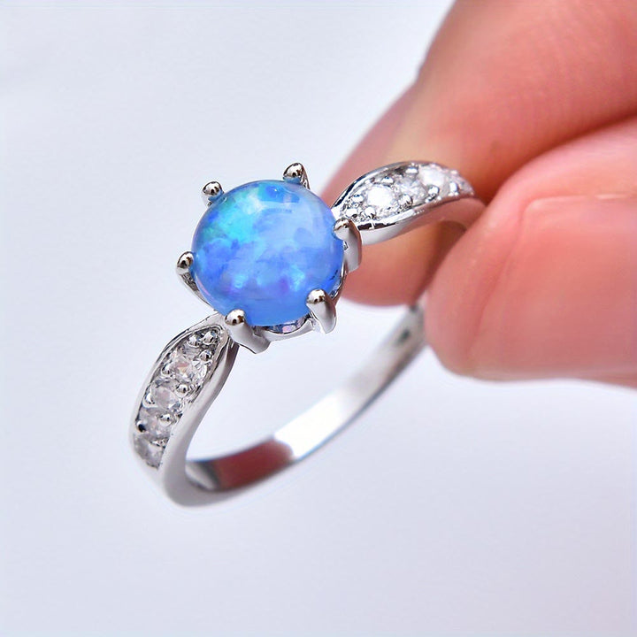 Anello Olivenorma con fascia a sei griffe e bordo in opale rotondo