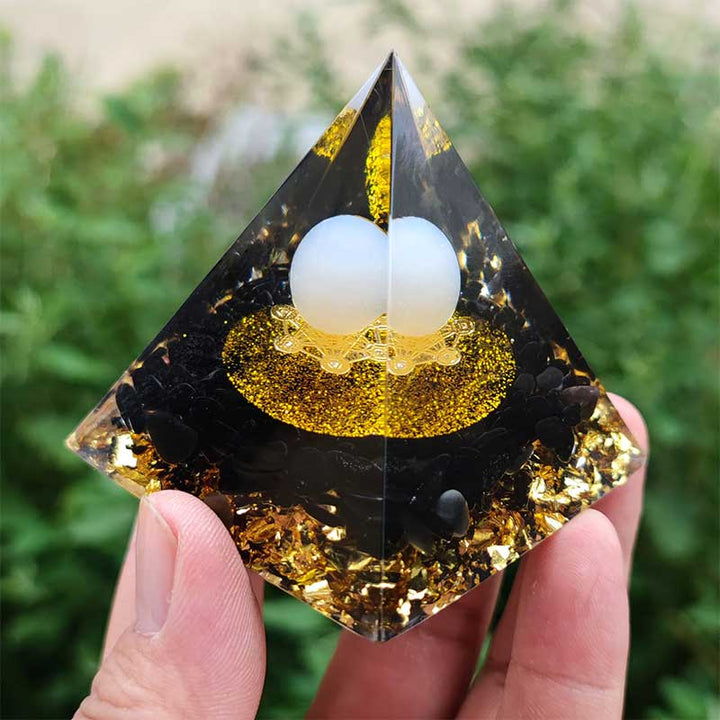 Sfera di agata bianca Olivenorma con piramide di orgone di ossidiana 