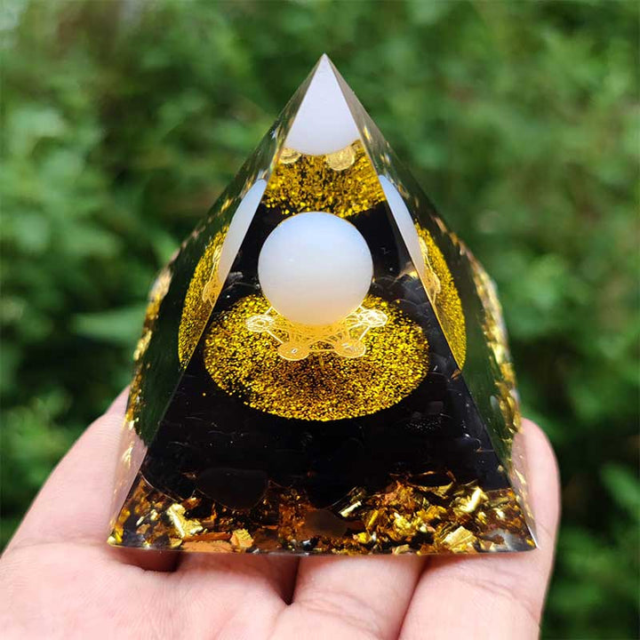Sfera di agata bianca Olivenorma con piramide di orgone di ossidiana 