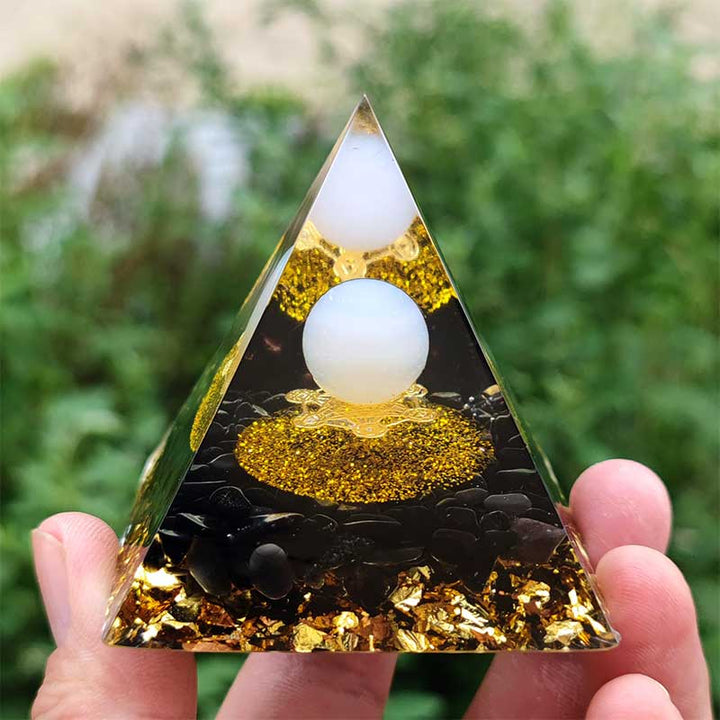 Sfera di agata bianca Olivenorma con piramide di orgone di ossidiana 