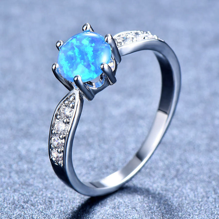 Anello Olivenorma con fascia a sei griffe e bordo in opale rotondo