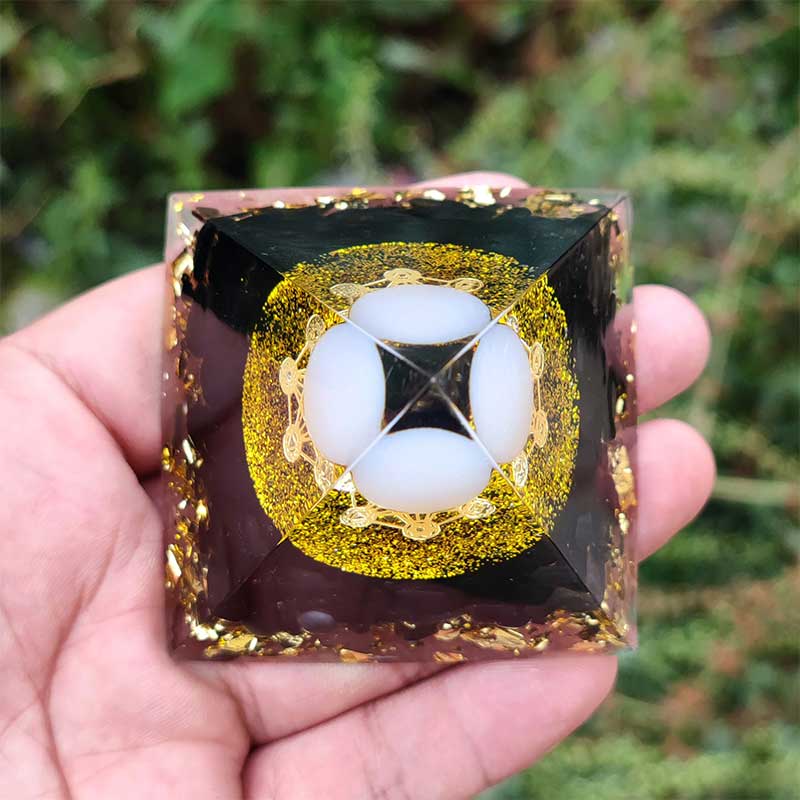 Sfera di agata bianca Olivenorma con piramide di orgone di ossidiana 